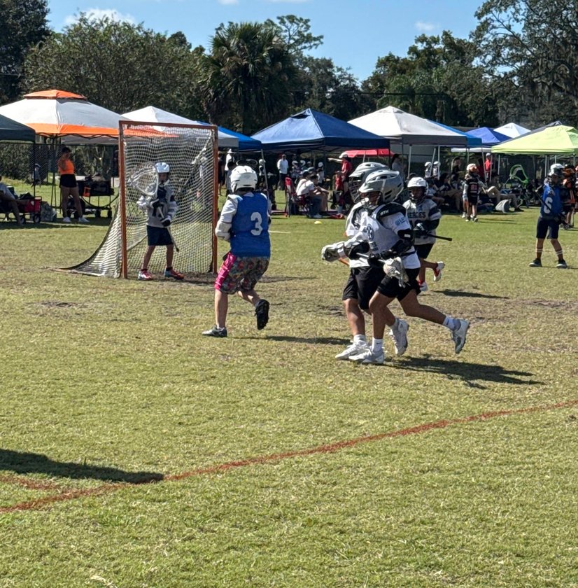 Youth lacrosse players competing in game