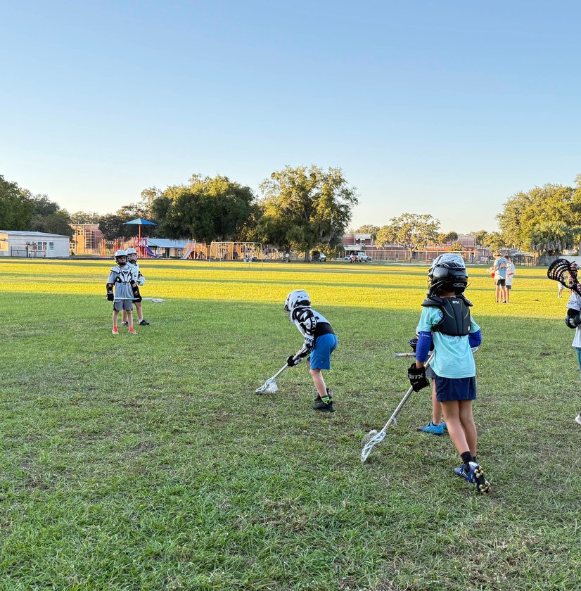 Youth lacrosse players competing in game